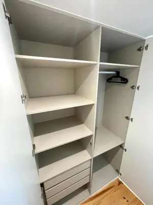 a walk in closet with white shelves at Cozy Studio in the Heart of Porto in Porto