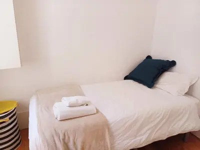a small bedroom with a bed with towels on a stool at Foryou-2-BonfimPorto in Porto