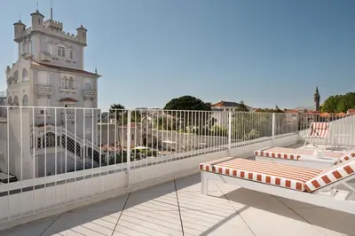 a balcony with two chairs and a building at Vila Catarina Luxury Apartments in Porto