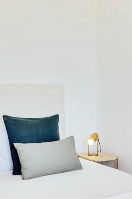 a white bed with a blue pillow on it at Rola Art Work Studio II by DA'HOME in Porto