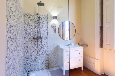 a bathroom with a shower with a sink and a mirror at Guesthouse Bonjardim by LovelyStay in Porto