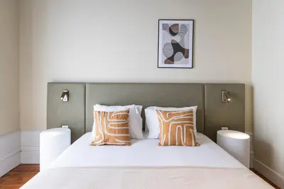 a bedroom with a large bed with orange and white pillows at Guesthouse Bonjardim by LovelyStay in Porto