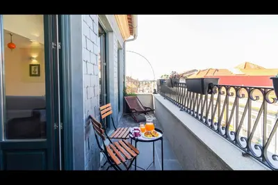 a balcony with two chairs and a table with drinks on it at AM Haven Studios - by Unique Hosts in Porto