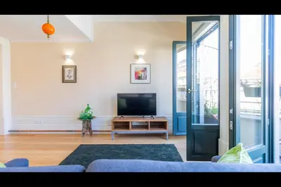 a living room with a tv and a blue couch at AM Haven Studios - by Unique Hosts in Porto