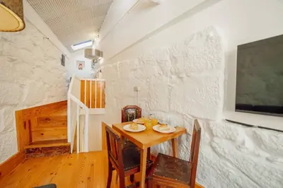 a dining room with a table and chairs and a wall at Charming Tiny House by Hosty in Porto