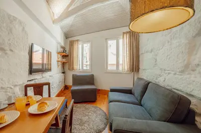 a living room with a couch and a table at Charming Tiny House by Hosty in Porto