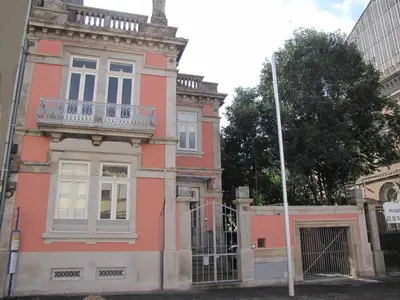 an old pink building with a balcony on a street at Koolhouse Porto in Porto