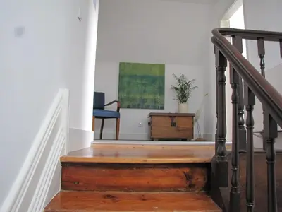a stairway with a blue chair and a painting at Koolhouse Porto in Porto