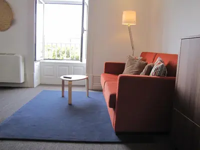 a living room with a red couch and a table at Koolhouse Porto in Porto