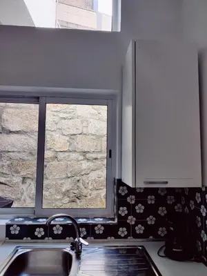 a kitchen with a sink and a window at Central Stonehouse with terrace in Porto