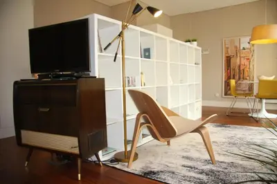 a living room with a tv and a chair at Toctoc Yellow in Porto