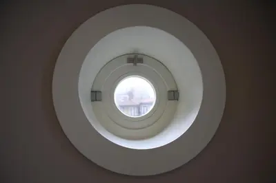 a round window in a wall with a window in it at Toctoc Yellow in Porto