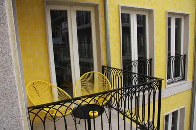 a balcony with two yellow chairs on a building at Toctoc Yellow in Porto