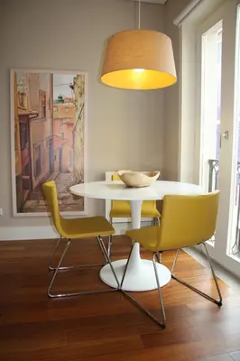 a dining room with a white table and yellow chairs at Toctoc Yellow in Porto