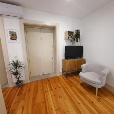 a living room with a chair and a television at Premium Apartment Porto Downtown - Bonjardim in Porto