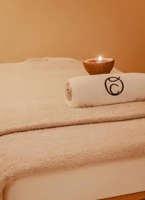 a candle sitting on top of a bed with towels at Palacete Severo in Porto