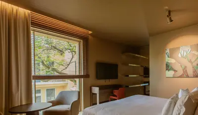 a bedroom with a bed and a window and a chair at Palacete Severo in Porto