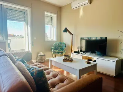 a living room with a couch and a tv at Premium Quental House - T3 Renovado com magnifico Terraço in Porto