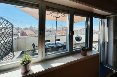 a window with two potted plants on a balcony at Premium Quental House - T3 Renovado com magnifico Terraço in Porto