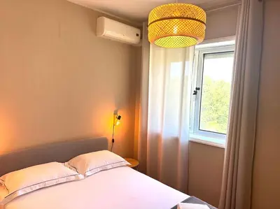 a bedroom with a bed and a window and a lamp at Premium Quental House - T3 Renovado com magnifico Terraço in Porto