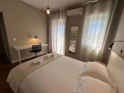 a bedroom with a large white bed and a desk at Premium Quental House - T3 Renovado com magnifico Terraço in Porto