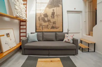 a living room with a couch and a painting at Clerigos Loft by Hosty in Porto