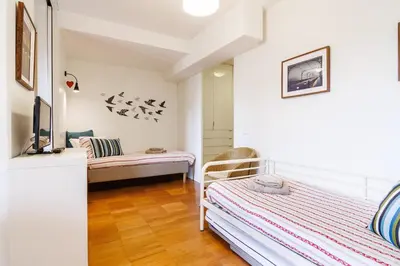 a bedroom with a desk and a bed and a room with a bed at Studios Cedofeita in Porto