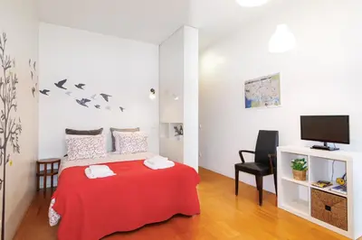 a bedroom with a red bed and a tv at Studios Cedofeita in Porto