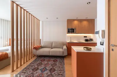 a living room with a couch and a kitchen at Doispontozero Alegria Terracotta in Porto