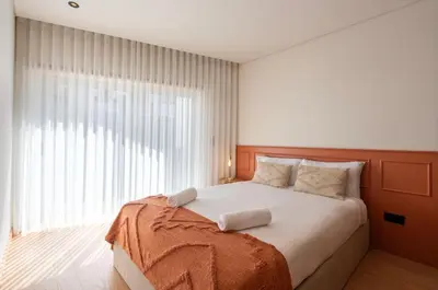 a bedroom with a large bed and a large window at Doispontozero Alegria Terracotta in Porto