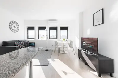 a white living room with a tv and a table at GuestReady - Porto Saudade in Porto