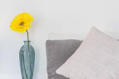 a vase with a yellow flower in it next to a pillow at GuestReady - Porto Saudade in Porto