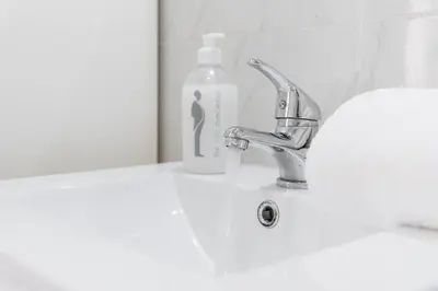 a bathroom sink with a faucet and a bottle of soap at GuestReady - Porto Saudade in Porto