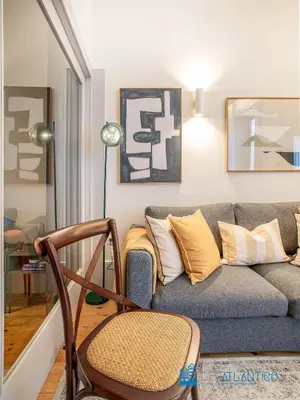 a couch with a pillow sitting on a chair at Boavista Central Garden & Terrace in Porto