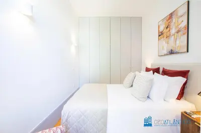 a bedroom with a white bed with red pillows at Boavista Central Garden & Terrace in Porto