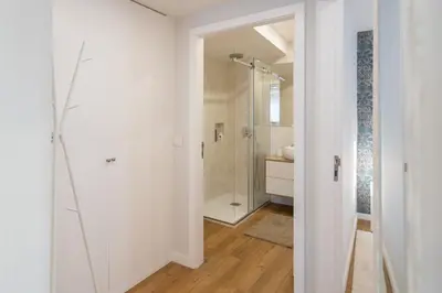 a white bathroom with a shower and a glass door at GuestReady - Stylish stay with balcony in Gaia in Vila Nova de Gaia