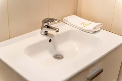 a bathroom sink with a faucet and a towel at Pinheiro Cardoso in Porto