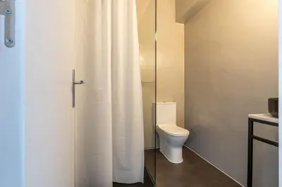 a bathroom with a toilet and a shower curtain at St Catarina 555 Apartment in Porto