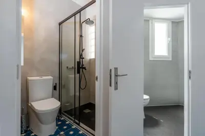 a bathroom with a toilet and a glass shower at St Catarina 555 Apartment in Porto