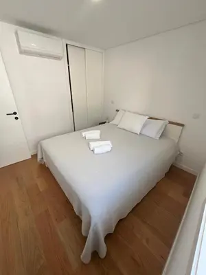a white bed with two towels on top of it at Cozy Retreat - Modern T1 in Porto