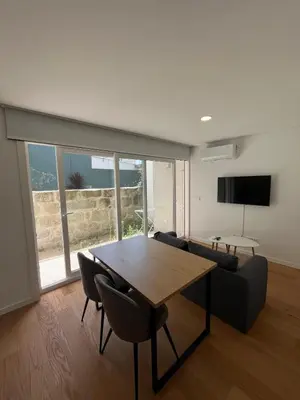 a living room with a table and a couch at Cozy Retreat - Modern T1 in Porto