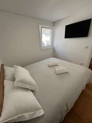 a bedroom with a white bed with two towels on it at Cozy Retreat - Modern T1 in Porto
