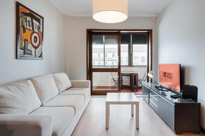 a living room with a white couch and a tv at GuestReady - Central Porto Gem in Porto