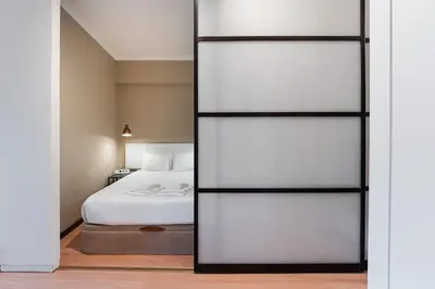 a bedroom with a bed and a glass wall at GuestReady - Central Porto Gem in Porto