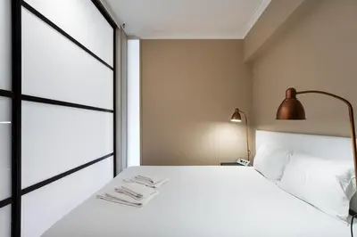 a bedroom with a white bed and a lamp at GuestReady - Central Porto Gem in Porto