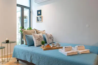 a blue bed with a tray of towels on it at Host Wise - Stylish Urban Flat with Terrace in Porto