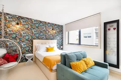 a bedroom with a bed and a blue chair at Boavista Loft in Porto