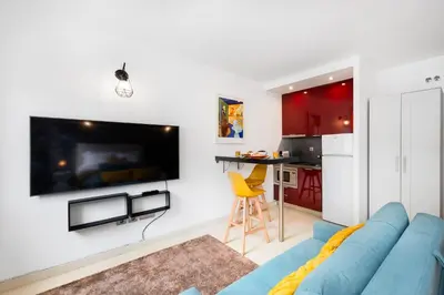 a living room with a blue couch and a kitchen at Boavista Loft in Porto