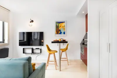 a living room with a blue couch and yellow chairs at Boavista Loft in Porto