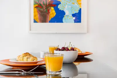 a table with a plate of food and a glass of orange juice at Boavista Loft in Porto
